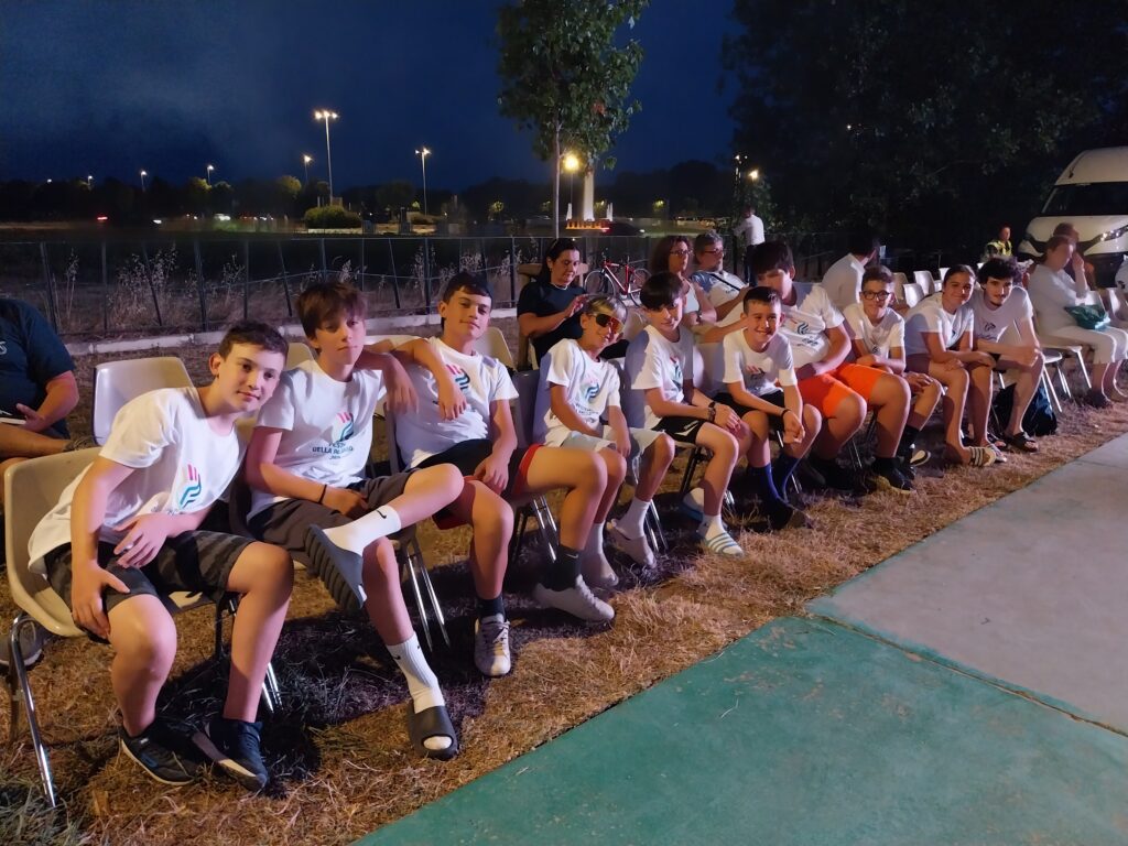 Giovani atleti in maglia del Festival seduti all'aperto durante la serata