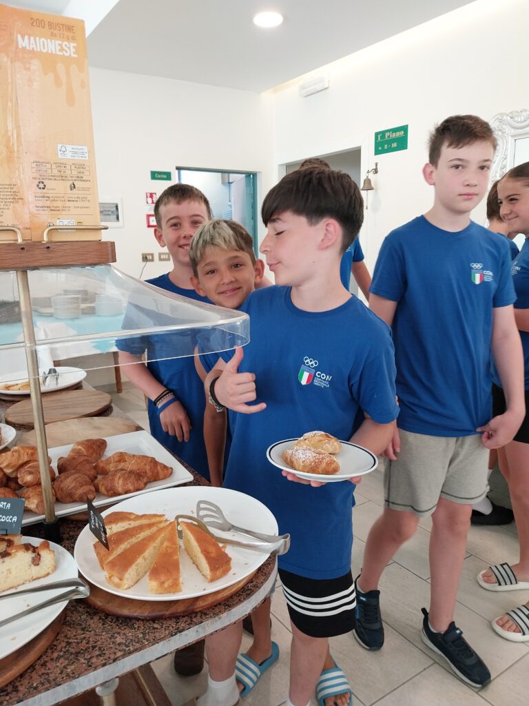 Giovane atleta mostra il piatto con i croissant della colazione