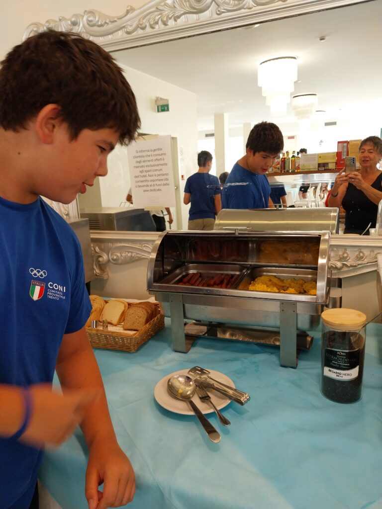 Giovani atleti al buffet caldo della colazione