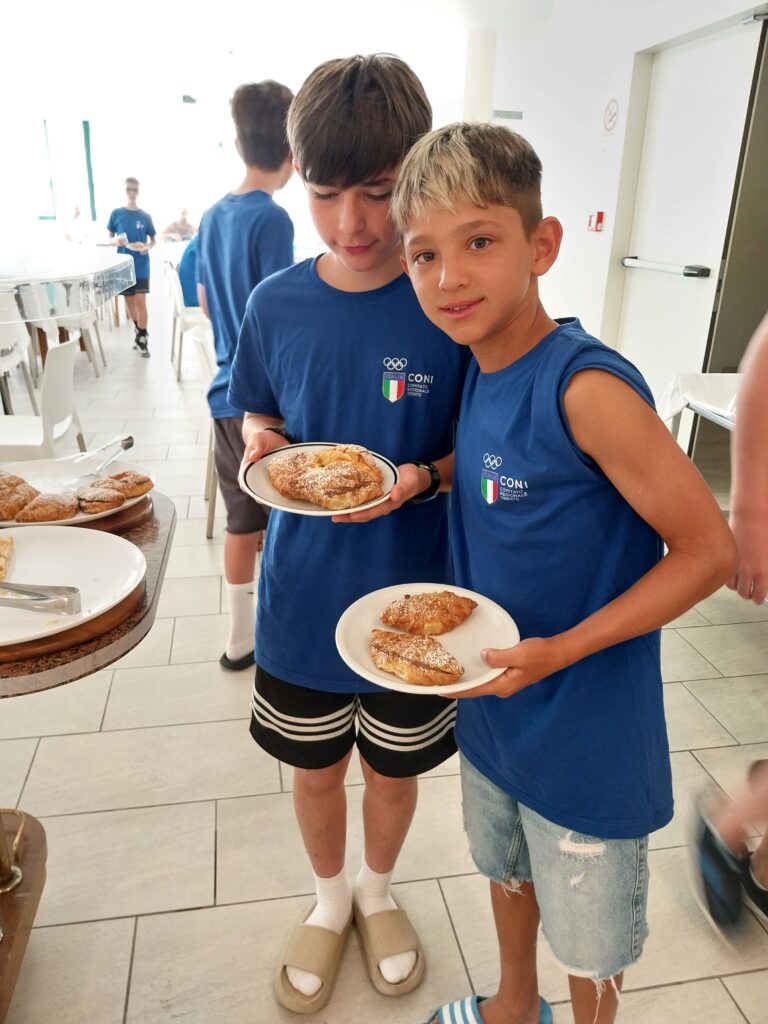 Due giovani atleti mostrano i piatti della colazione