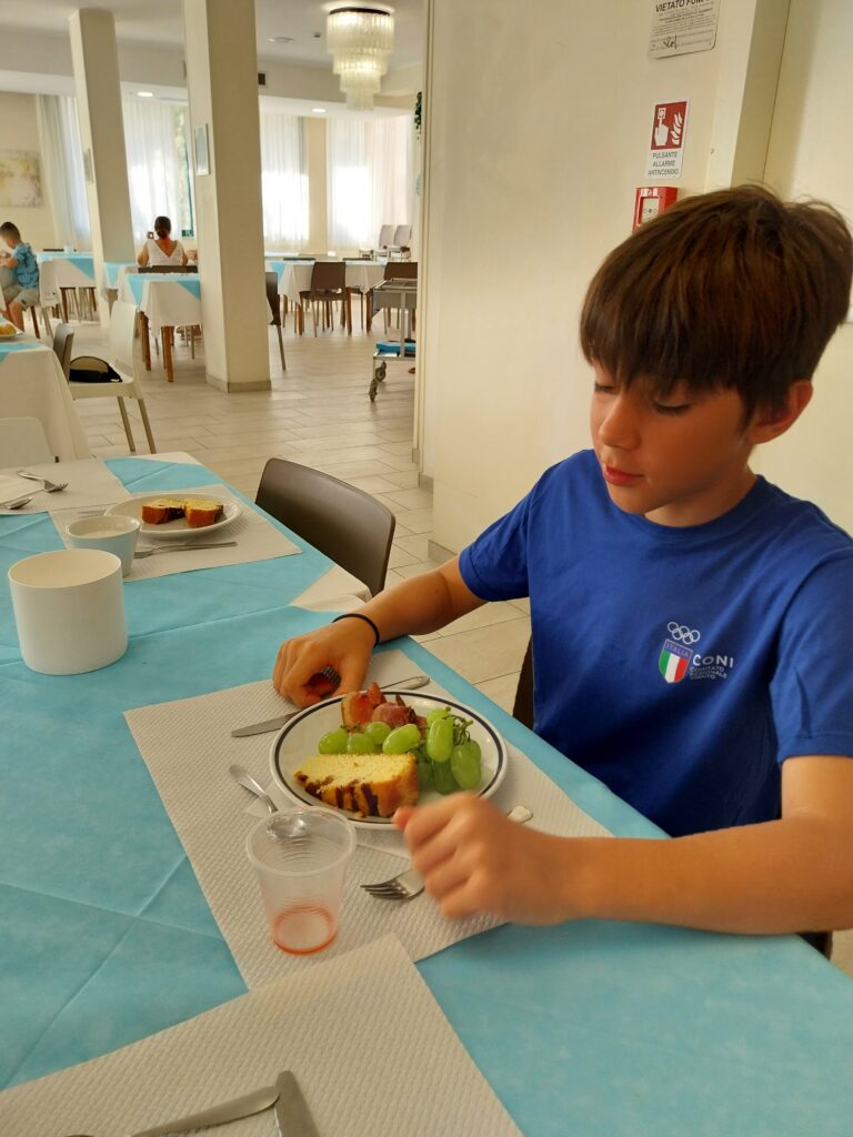 Giovane atleta fa colazione al tavolo