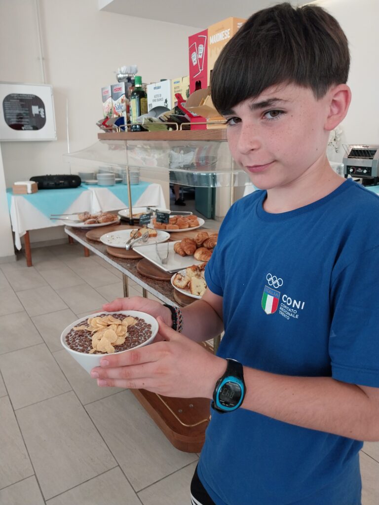 Giovane atleta con una ciotola al buffet della colazione