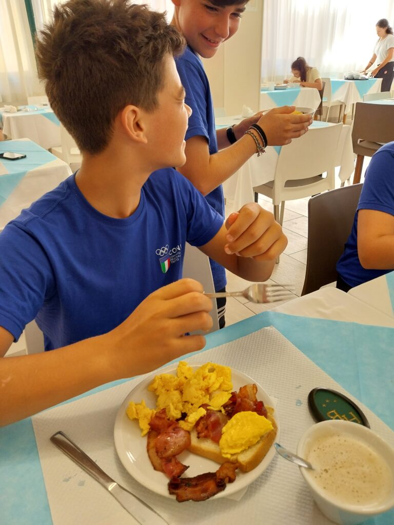 Giovane atleta si serve al buffet della colazione
